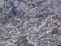 Cracks and shapes emerge from this close up portion of black solidified lava on the island of Hawaii