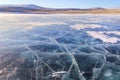 Cracks on the surface of the blue ice. Frozen lake in winter mountains on Lake Baikal