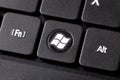 The Windows button on a black laptop notebook keyboard macro extreme closeup top view Round dedicated operating system key