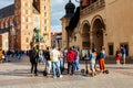 A group of people on electric scooters standing on the market square in front of St. Mary Basilica. Electric scooter usage, tours