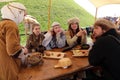 Group of young people wearing medieval costumes sitting at the table