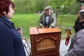 Male vintage costumed street entertainer playing barrel organ.