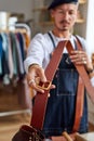 crafstman in apron working with leather belt at workshop Royalty Free Stock Photo