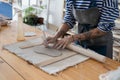 Craft artist making object out of clay in studio, using fettling knife, creating handmade pottery Royalty Free Stock Photo