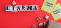 Craft bag with popcorn two yellow cinema tickets puzzle wooden cubes with text cinema red background Royalty Free Stock Photo