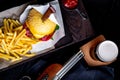 Craft beef burger and french fries on table in restaurant with glass of beer on dark background. Modern fast food lunch Royalty Free Stock Photo