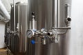 Craft beer brewing equipment in brewery. Metal tanks, alcoholic drink production. Facilities in modern interior of brewery. Manufa