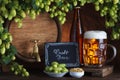 Craft bottled and unbottled beer with barrel, barley and fresh hops Royalty Free Stock Photo