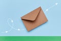 Craft brown envelope flying above green paper ground with indicated direction by white points and arrows depicted with