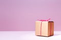 Craft cardboard gift box on the solid pink background. Holiday a Royalty Free Stock Photo