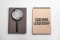 Craft colour notepad with text coaching leadership. Notepad with , magnifying glass. Business concept Royalty Free Stock Photo