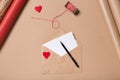 Craft envelope with red heart, blank paper and pen on beige table. Wrapping. Love concept. Saint Valentine`s Day concept Royalty Free Stock Photo