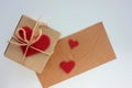 Craft gift box and envelope with red fabric hearts on white background. Happy Valentine`s day concept. Royalty Free Stock Photo