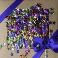 craft gift box with satin blue bow and colorful stars Royalty Free Stock Photo