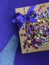 craft gift box with satin blue bow and colorful stars Royalty Free Stock Photo
