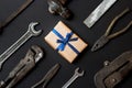 Craft gift with vintage old tools on black paper background. Fathers day concept. Flat lay Royalty Free Stock Photo