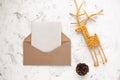 Craft kraft paper envelope, fir cone and vine deer on light background, flat lay, top view