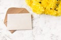 Craft kraft paper envelope and yellow chrysanthemum flowers on a light background. Flat workspace. Flat lay, top view