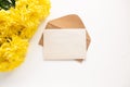 Craft kraft paper envelope and yellow chrysanthemum flowers on a light background. Flat workspace. Flat lay, top view