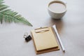 Craft notebook, note paper, pen, coffee cup and fern leaf on beige background Royalty Free Stock Photo
