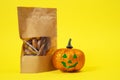 Craft package with transparent top with tasty dried snacks for pets inside with halloween pumpkin lantern jack on yellow