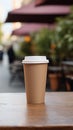 Craft paper biodegradable disposable cup with lid for hot drinks on a wooden table of street cafe. Tea or coffee to take Royalty Free Stock Photo