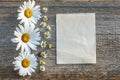 Craft paper on a wooden background with large and small daisies Royalty Free Stock Photo