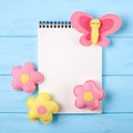 Craft pink and yellow butterfly and flowers with white paper, copyspace on blue wooden background. Hand made felt toys. Abstract s Royalty Free Stock Photo