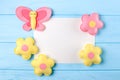 Craft pink and yellow butterfly and flowers with white paper, copyspace on blue wooden background. Hand made felt toys. Abstract s Royalty Free Stock Photo