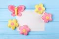 Craft pink and yellow butterfly and flowers with white paper, copyspace on blue wooden background. Hand made felt toys. Abstract s Royalty Free Stock Photo