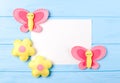 Craft pink and yellow butterfly and flowers with white paper, copyspace on blue wooden background. Hand made felt toys. Abstract s Royalty Free Stock Photo