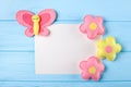 Craft pink and yellow butterfly and flowers with white paper, copyspace on blue wooden background. Hand made felt toys. Abstract s Royalty Free Stock Photo