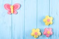 Craft pink and yellow butterfly and flowers with white paper, copyspace on blue wooden background. Hand made felt toys. Abstract s Royalty Free Stock Photo