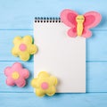 Craft pink and yellow butterfly and flowers with white paper, copyspace on blue wooden background. Hand made felt toys. Abstract s Royalty Free Stock Photo