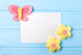 Craft pink and yellow butterfly and flowers with white paper, copyspace on blue wooden background. Hand made felt toys. Abstract s Royalty Free Stock Photo