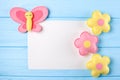 Craft pink and yellow butterfly and flowers with white paper, copyspace on blue wooden background. Hand made felt toys. Abstract s Royalty Free Stock Photo