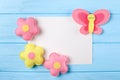 Craft pink and yellow butterfly and flowers with white paper, copyspace on blue wooden background. Hand made felt toys. Abstract s Royalty Free Stock Photo