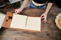 Craft wooden photo album with old yellow pages lying on a table.Old-fashioned book for storing printed pictures. Sentimental