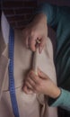 Craft workshop for tailoring. Young seamstress repairing a men`s light jacket, measuring the dimensions on a mannequin. Toning, Royalty Free Stock Photo