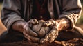 Soiled hand shaping clay in an outdoor workshop