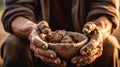 Soiled hand shaping clay in an outdoor workshop