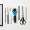 Crafting tools arranged on a white surface include a black and white grid cutting mat, Royalty Free Stock Photo
