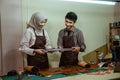 craftman and craftwoman in veil holding a leather belt