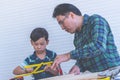 Craftman Father teaching his boy to work on construction woodwork tools Royalty Free Stock Photo
