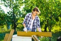 Crafts woman in protective glasses and gloves doing woodwork in summer garden