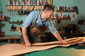 Craftsman in apron working with leather at workshop, belt manufacturing process. Royalty Free Stock Photo