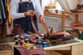 cropped young craftsman in apron working with leather at workshop Royalty Free Stock Photo