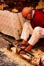 Craftsman carving wood at a market stall