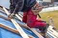 Craftsman or construction worker install a new roof, roofing tools, new metallic roof or metal sheet, building concept Royalty Free Stock Photo