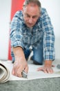 craftsman cutting carpet with cutter Royalty Free Stock Photo